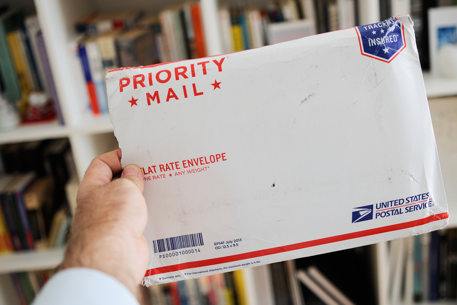 Usps United States Postal Service Parcel Envelope In Man's Hands